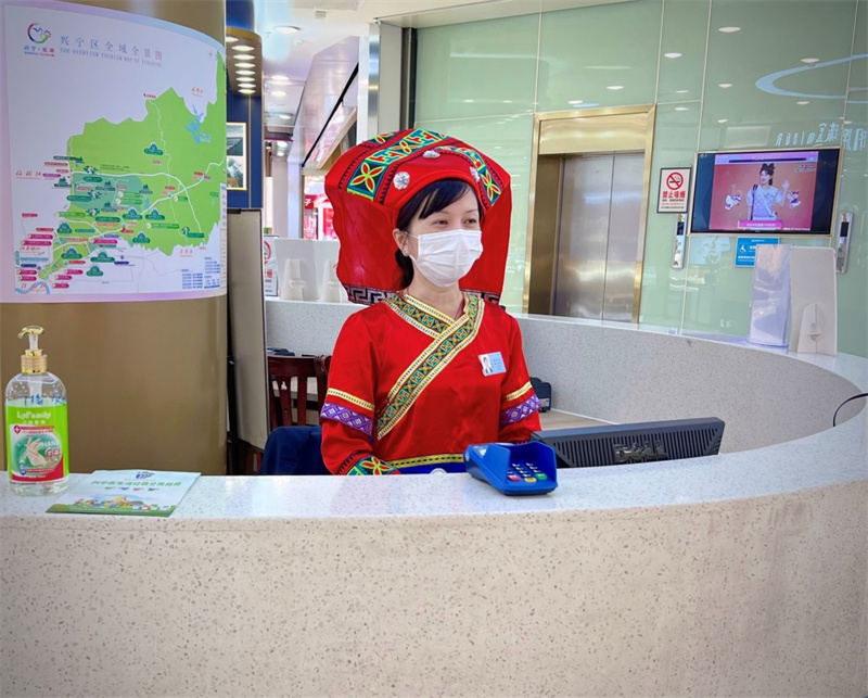 百貨朝陽(yáng)店收銀員身穿壯族民族服裝接待顧客.jpg